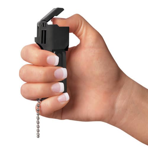 Mace® Pocket Model Triple Action Pepper Spray In Hand Demonstrating Thumb on Self Defense Button