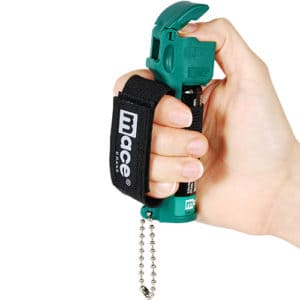 Mace® Canine Repellent Viewed in Hand Demonstrating Wrist Strap with Thumb On Trigger