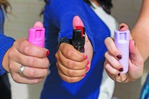 Women Pointing Multi Colored Pepper Spray